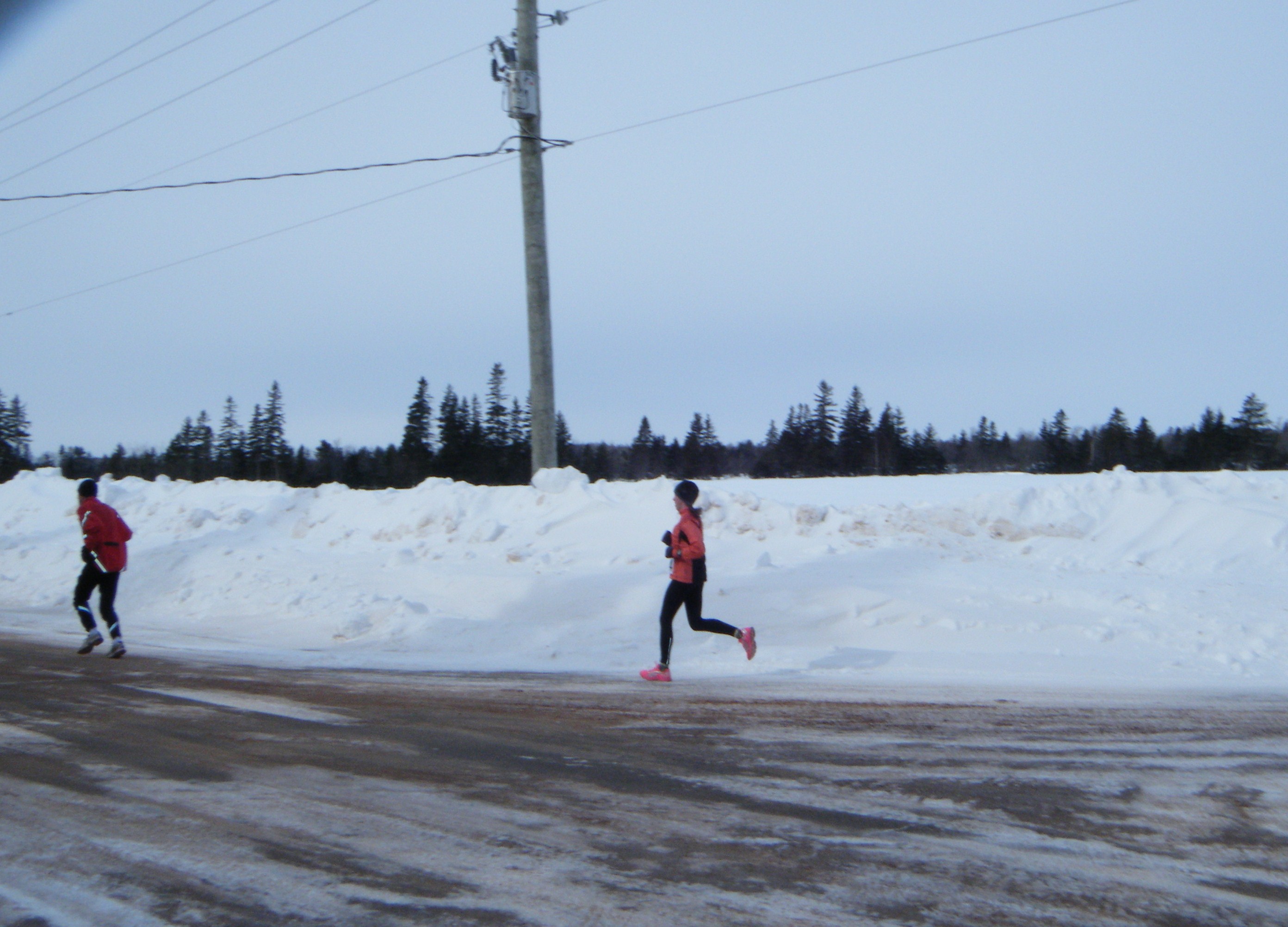Winter Half marathon runners surrounded by snowbanks