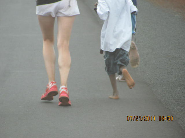 A Canadian girl runs with a barefoot African Child